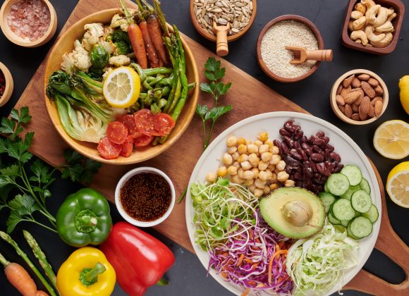 Vegan protein source. Buddha bowl dish, avocado, pepper, tomato, cucumber, red cabbage, chickpea, fresh lettuce salad and walnuts, nuts, beans, . Healthy vegetarian eating, super food. Top view.